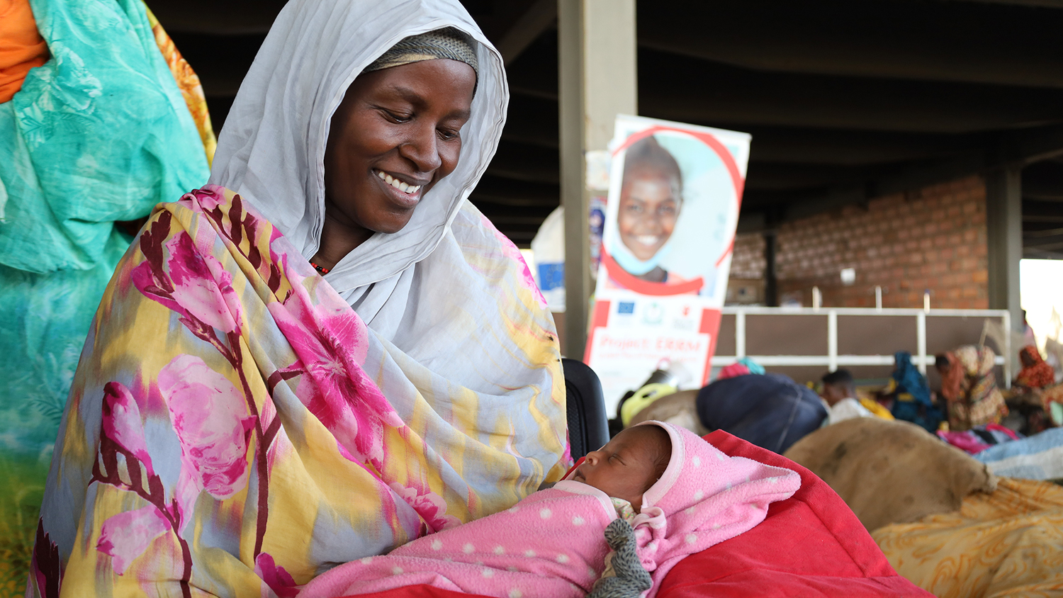 Nainen pit&auml;&auml; vauvaa syliss&auml;&auml;n.